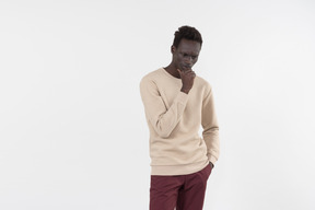 A young black man in a grey sweater standing alone on the white background