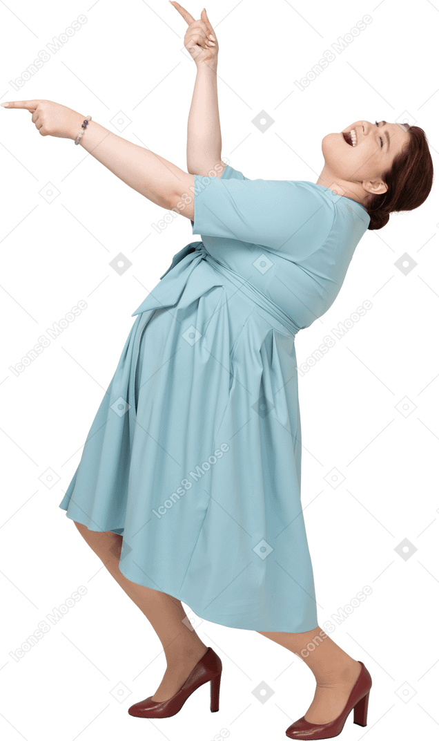 Vista laterale di una donna in abito blu che balla