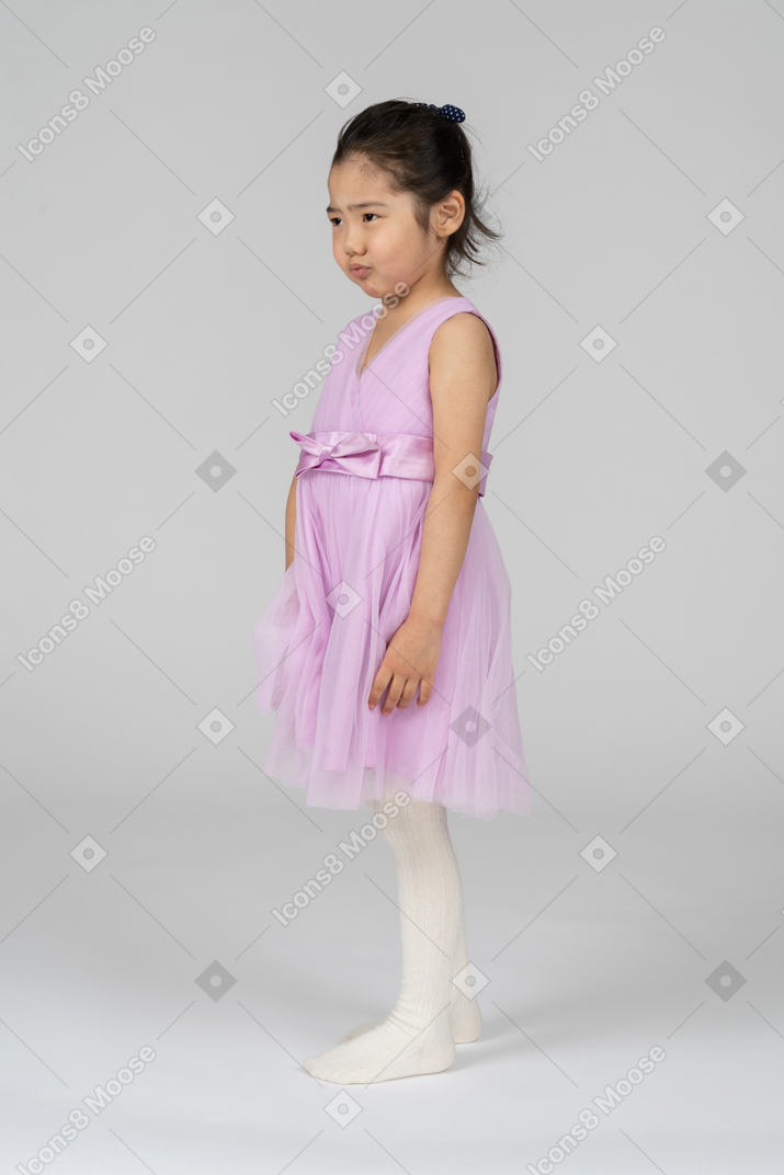 핑크 드레스를 입은 아시아 소녀는 실망스러워 보인다