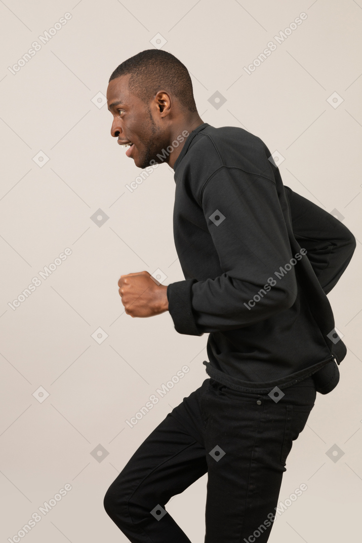 Side view of young man running