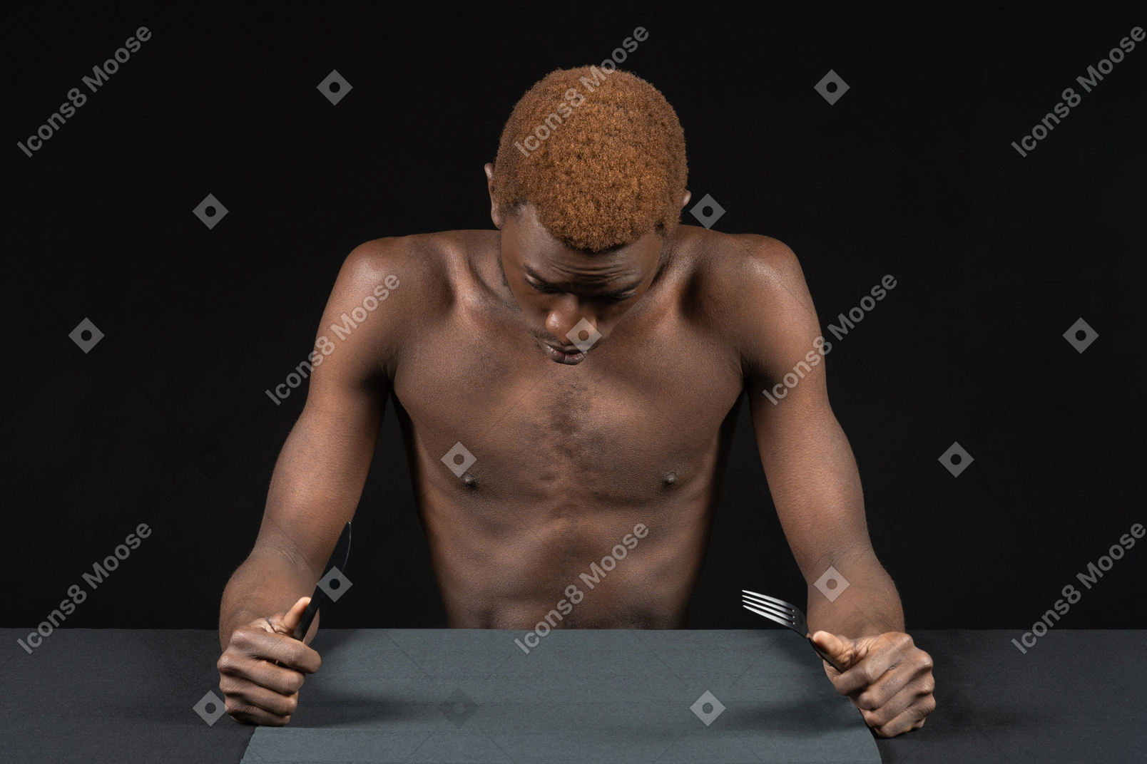 Front view of a young afro man sitting with no food at the table