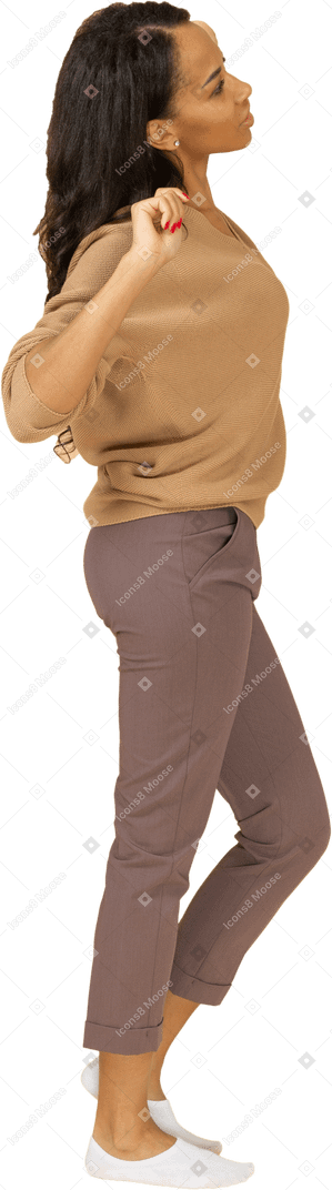 Vista lateral de una mujer joven de piel oscura soñolienta estirando su espalda