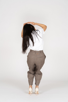 Back view of a scared young woman in breeches touching her head