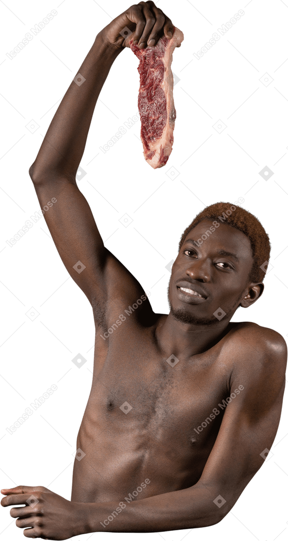 Front view of a young afro man holding a slice of meat