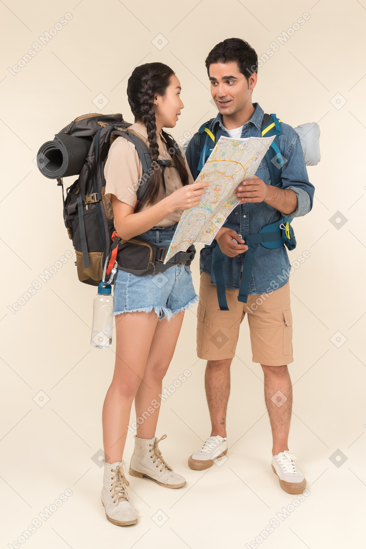 Young interracial couple looking at map