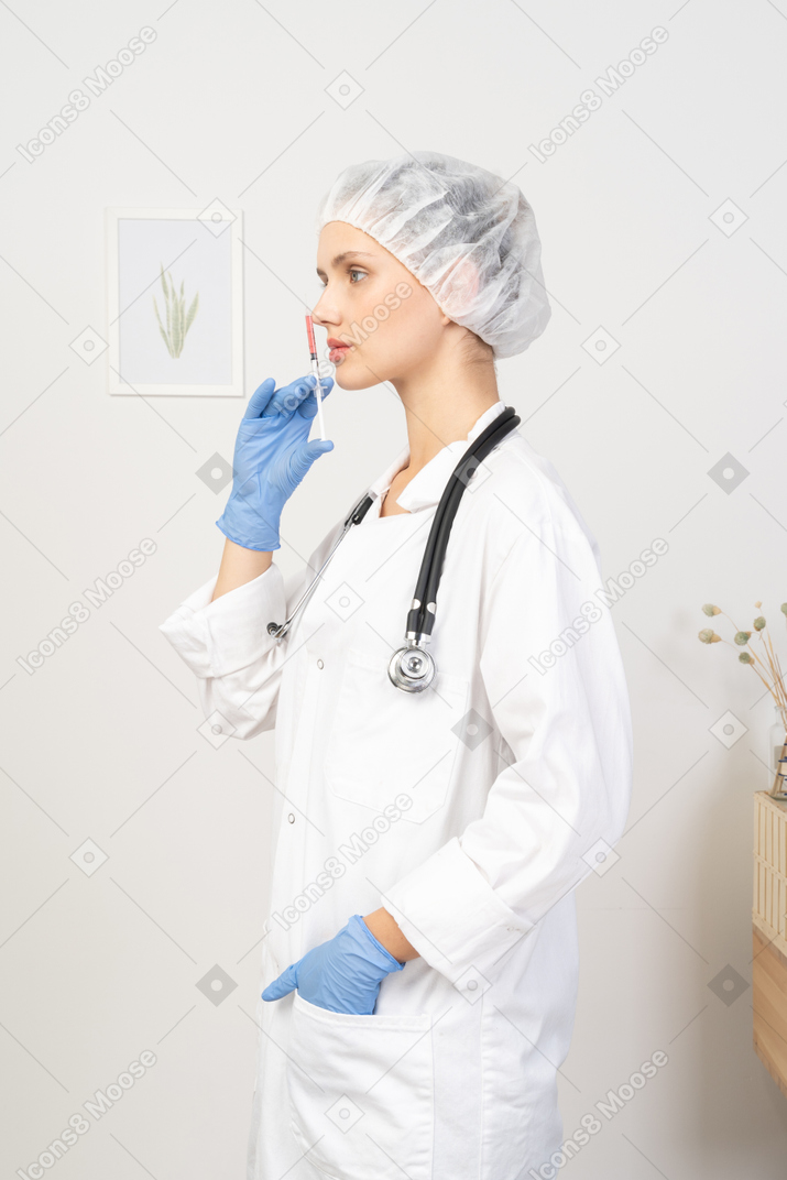 一位年轻女医生拿着注射器的侧视图