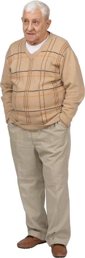Front view of an old man in casual clothes standing with hands in pockets