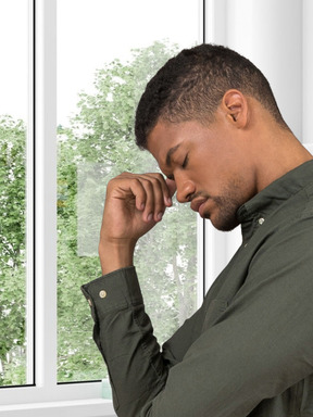 Thoughtful man standing in front of window