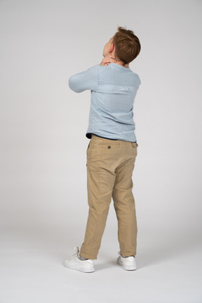 Boy standing back to camera and looking up