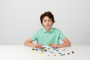 Teen boy playing with construction set