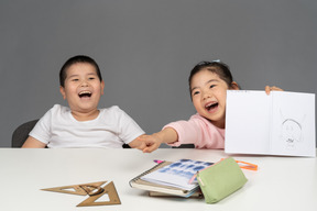 Niña señalando y riendo con su hermano