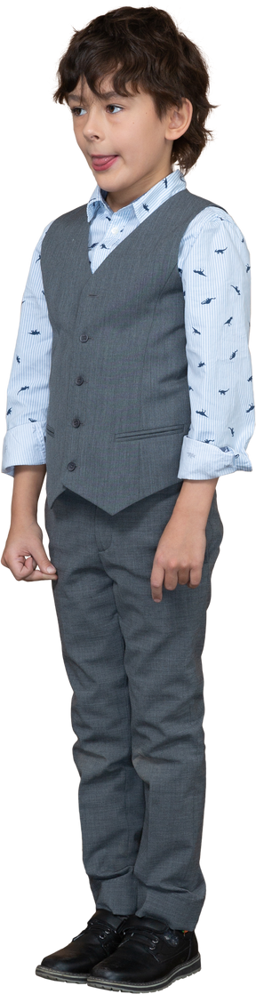 Vista frontal de um lindo garoto de terno cinza mostrando a língua
