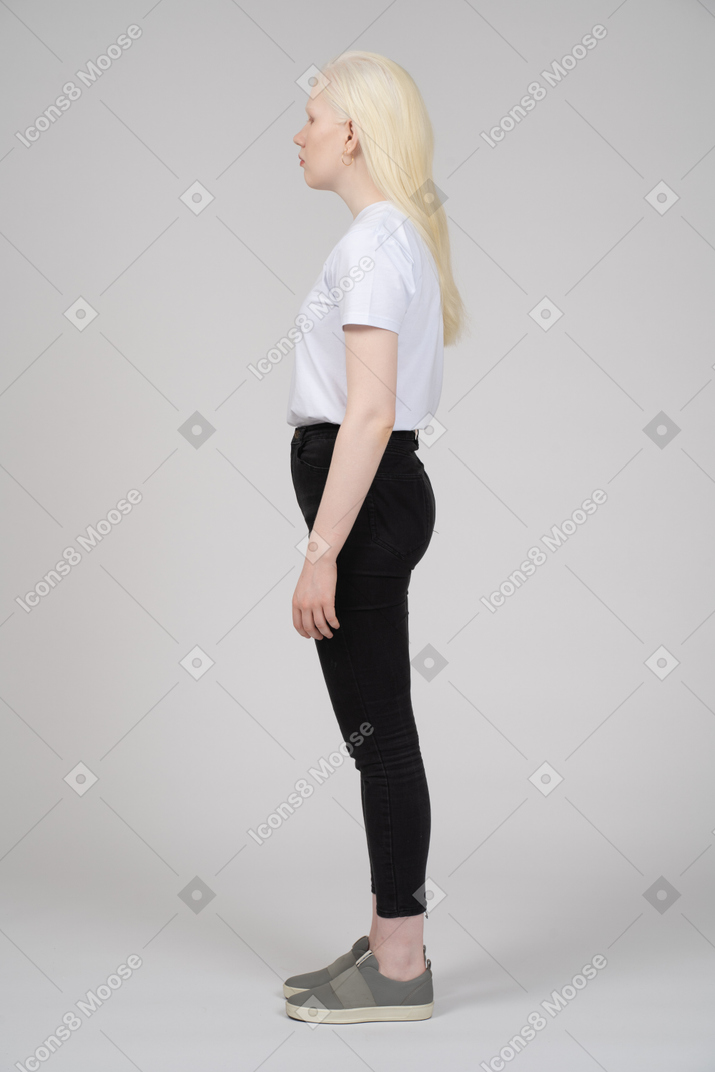 Side view of a teenage girl with arms at sides