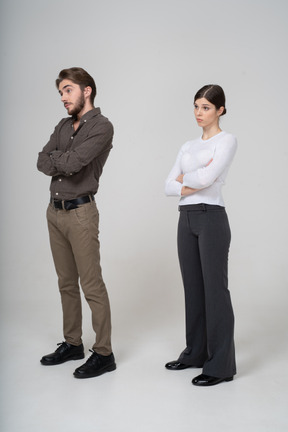 Three-quarter view of a young couple in office clothing crossing arms