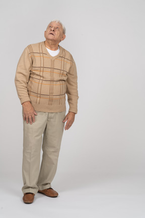Вид спереди на старика в повседневной одежде, смотрящего вверх