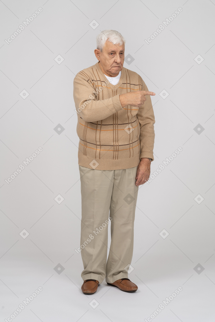Vorderansicht eines alten mannes in freizeitkleidung, der mit dem finger zeigt