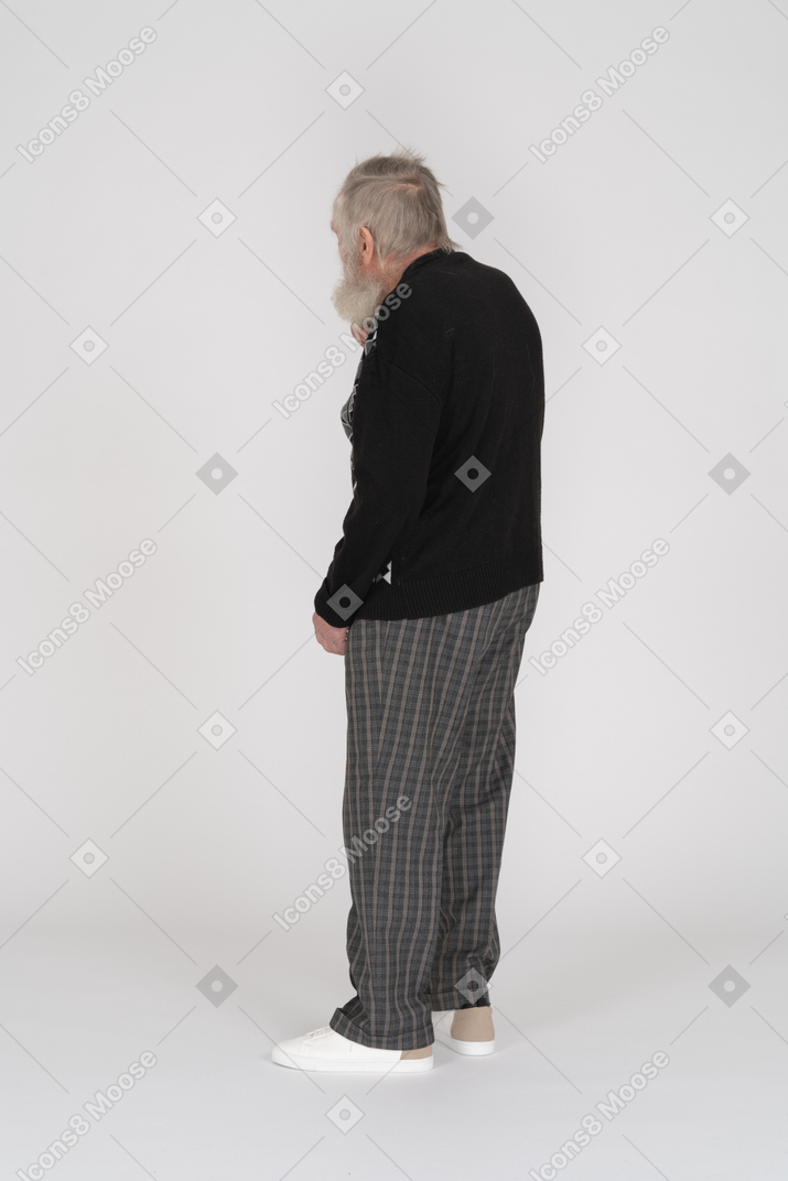 Пожилой мужчина стоит и смотрит в сторону