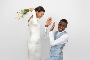 La mariée va frapper son fiancé avec le bouquet