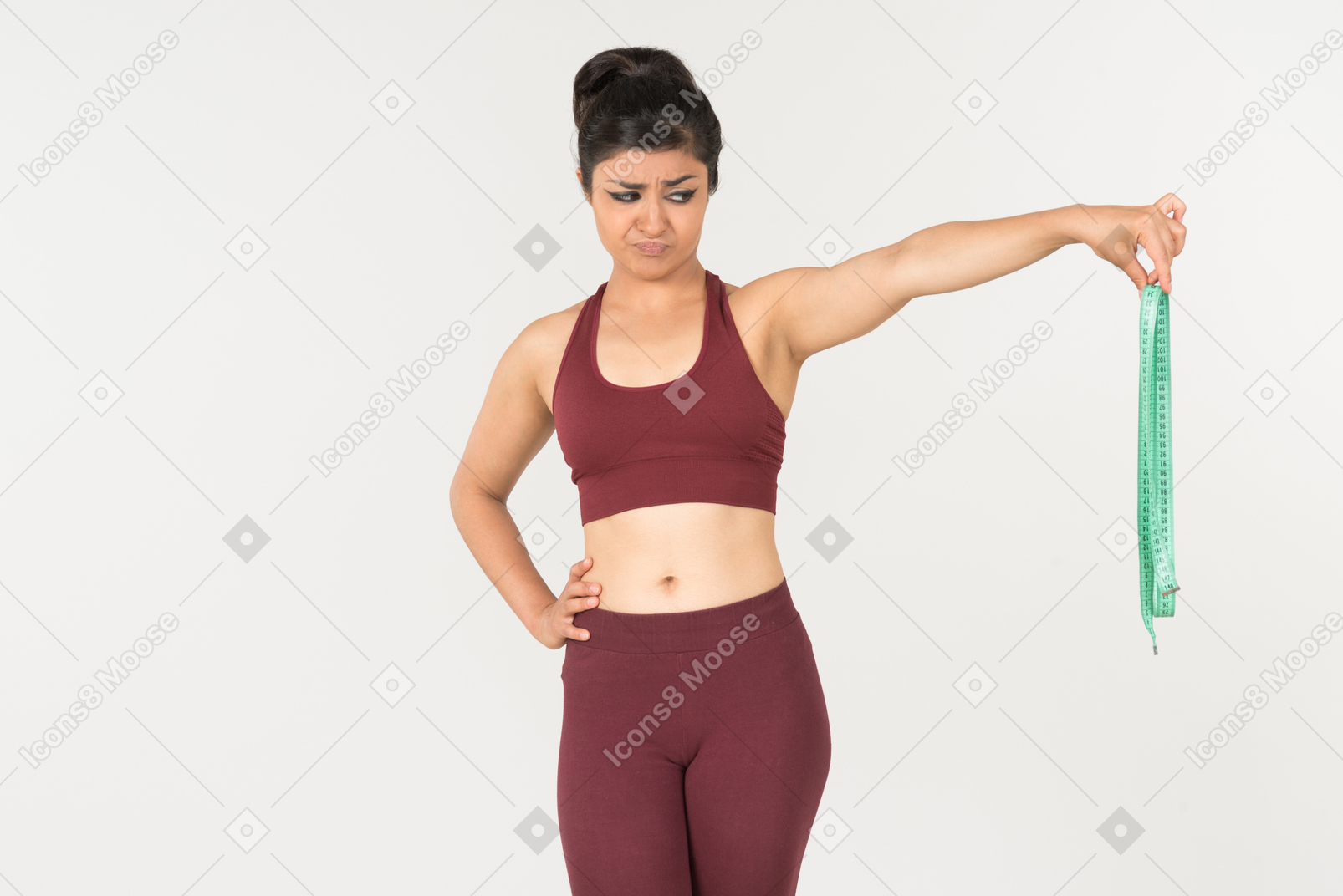 Young indian woman in sportswear looking with disgust on cloth ruler
