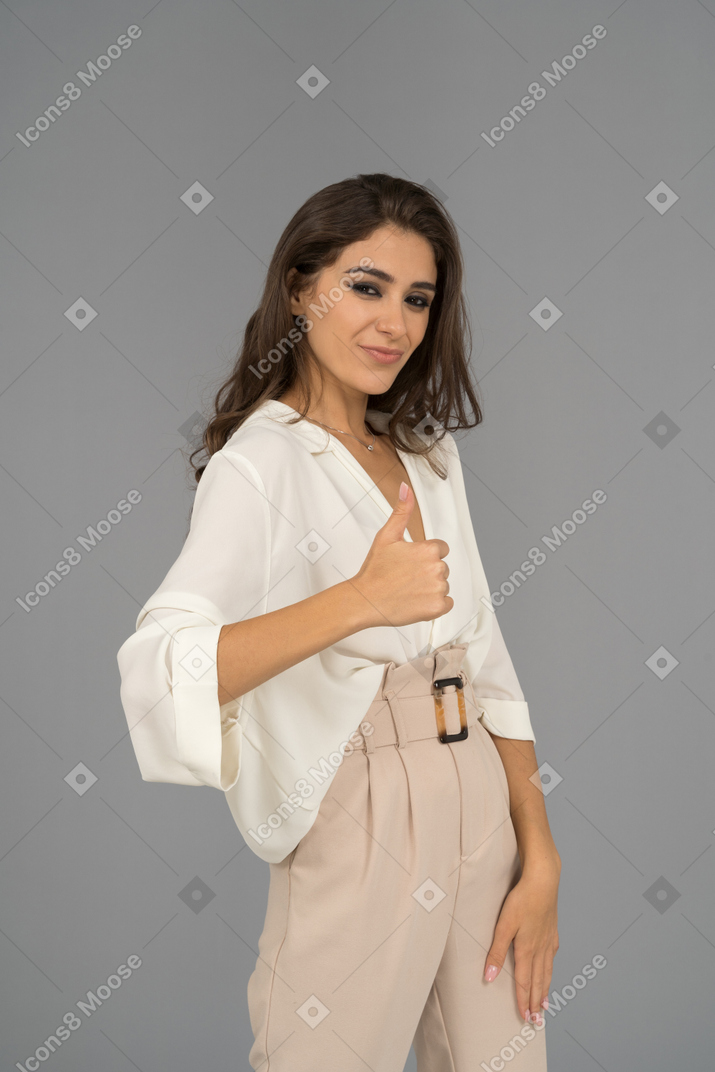 Cheerful brunette female giving a thumb up