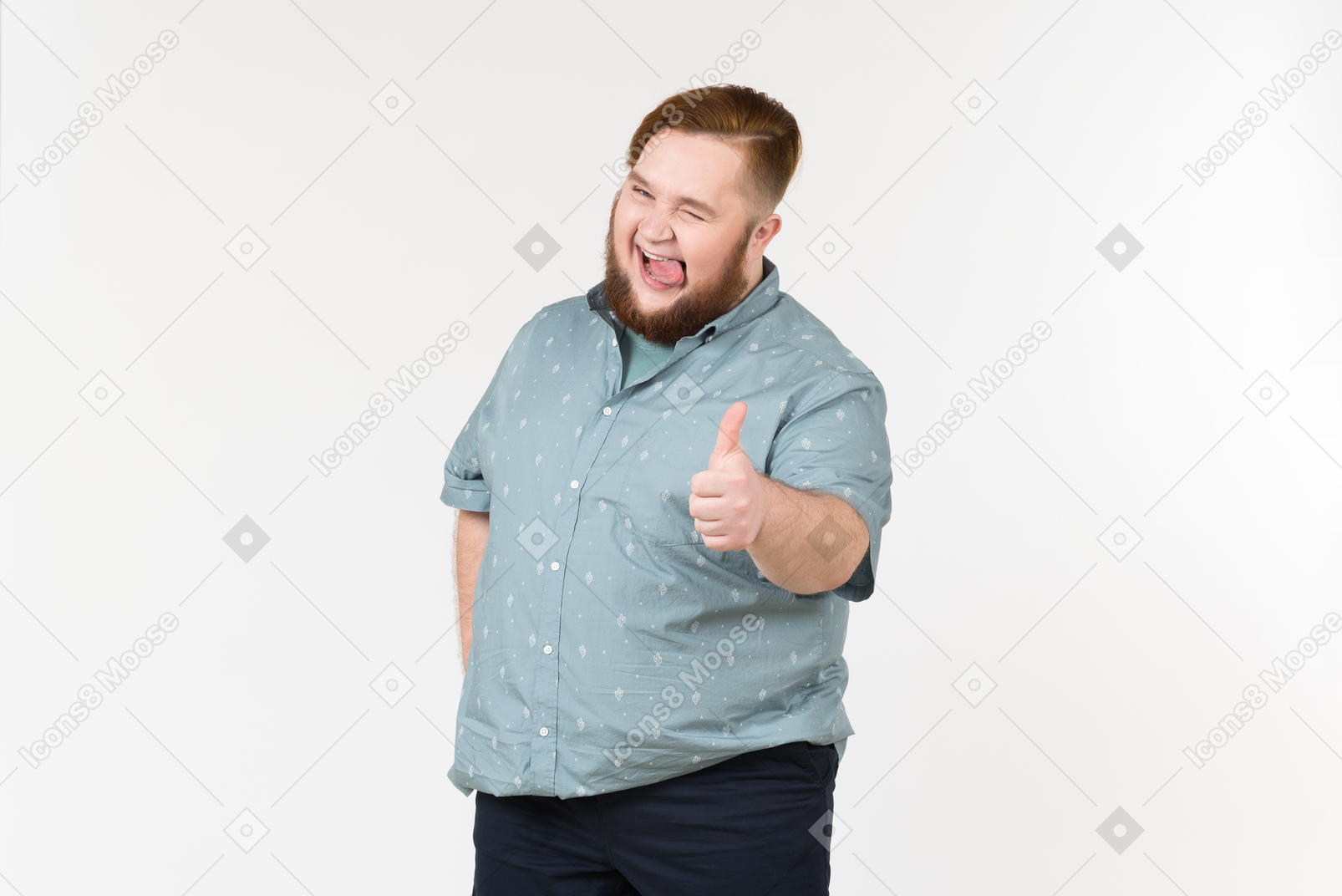 Excited young overweight man sticking tongue out and showing thumb up