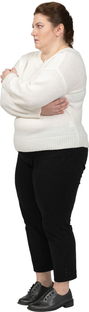 Plus size woman in casual clothes standing in profile with arms crossed