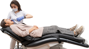 Pleine longueur d'une femme dentiste extrayant la dent de son patient