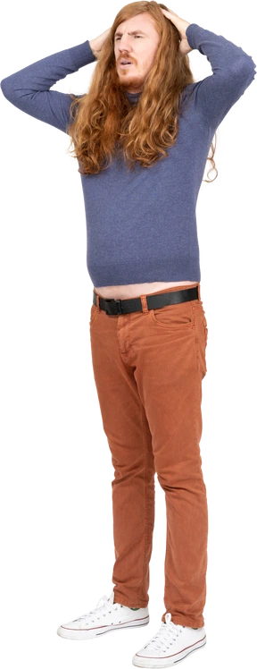 Front view of a young man standing with hands behind head