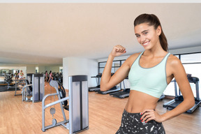 A woman flexing her muscles in a gym