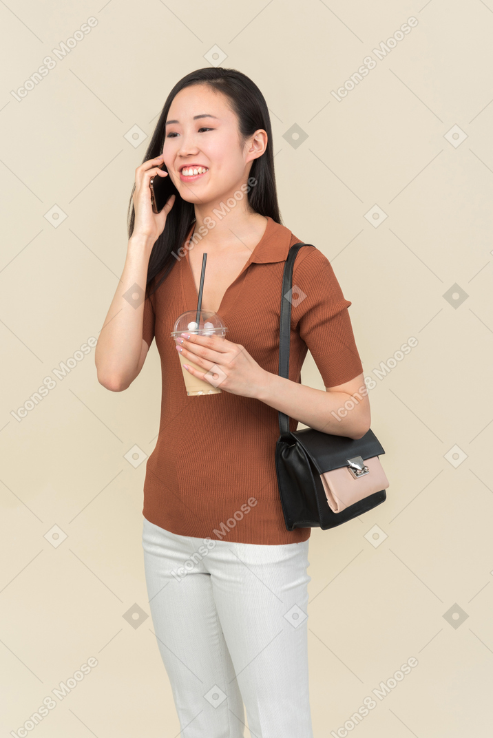 Smiling young asian girl talking on the phone