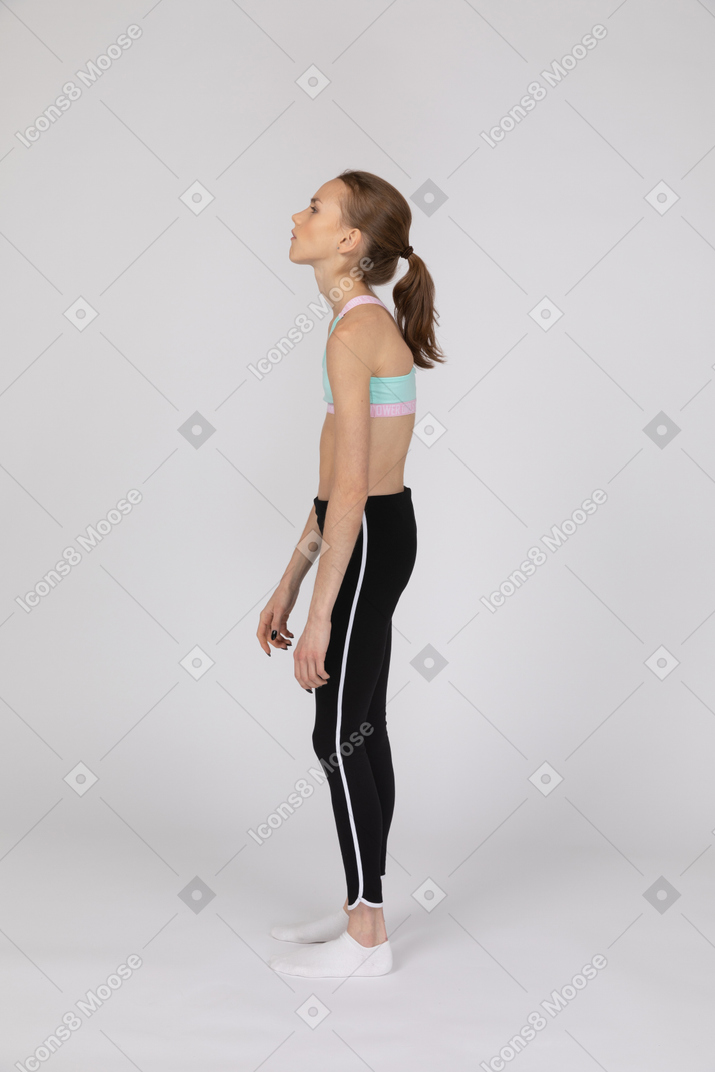 Vista lateral de una adolescente exhausta en ropa deportiva.