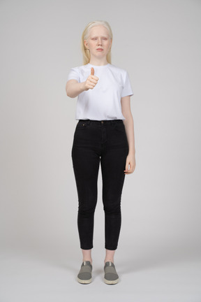 Front view of a young woman standing and showing thumbs up