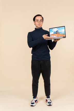 Young asian man presenting a laptop