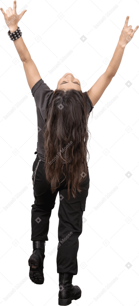 Vista traseira de uma jovem mulher recostada e mostrando o gesto de pedra