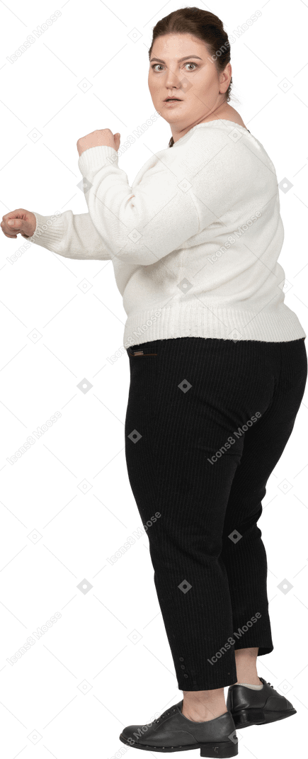 Scared plus size woman in casual clothes is ready to fight