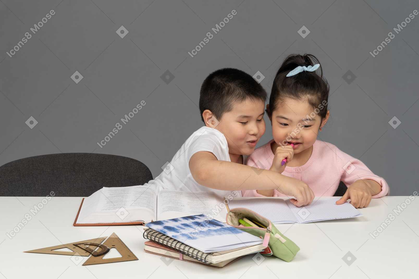 Brother and sister helping each other do homework