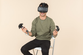 Молодой кавказский парень играет в игру виртуальной реальности