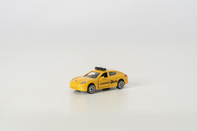 Yellow toy car on grey background