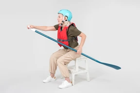 Mature woman in helmet sitting and learning how to paddle