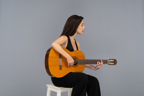 Beautiful woman playing guitar with closed eyes