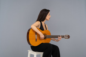 Hermosa mujer tocando la guitarra con los ojos cerrados