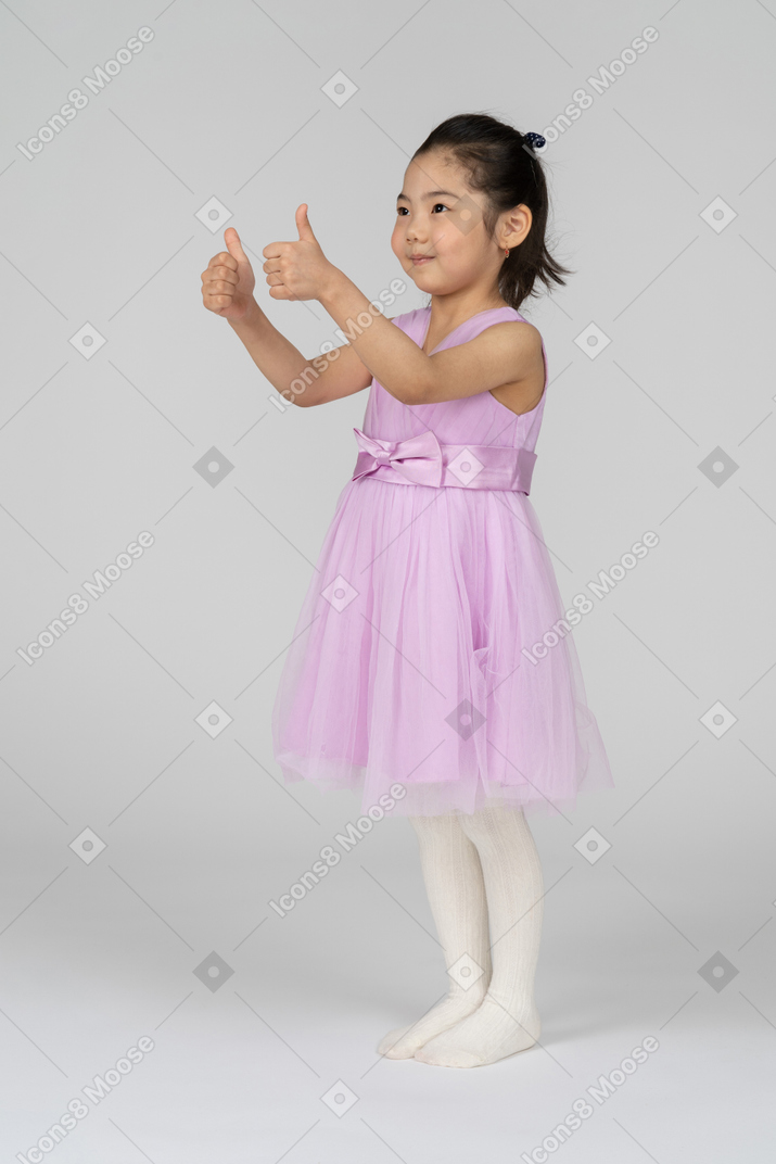 Retrato de uma menina bonitinha mostrando os polegares
