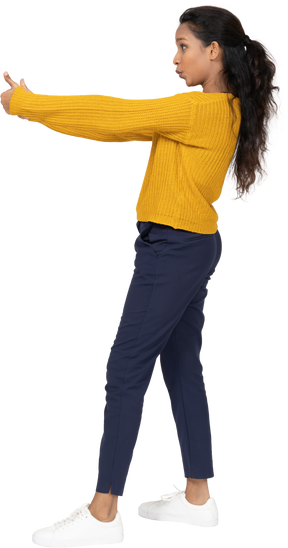 Side view of a girl in casual clothes showing thumbs up