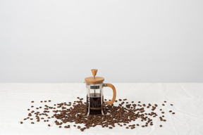 フレンチプレスのコーヒーと散在のコーヒー豆
