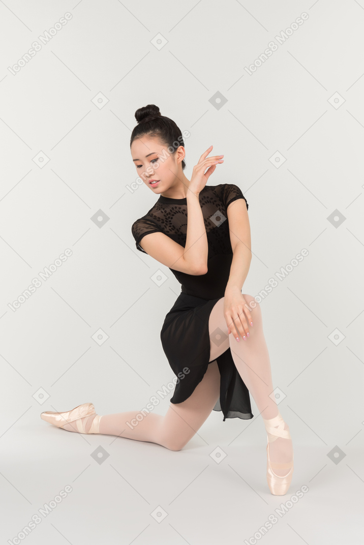 Jovem bailarina asiática em pé na posição de balé