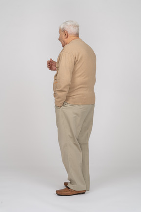 一位穿着休闲服的老人解释某事的侧视图