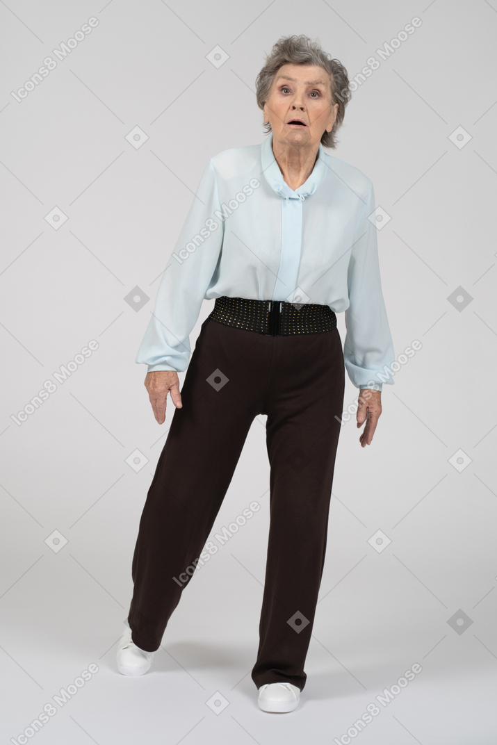 Front view of an old woman stepping forward with a shocked expression
