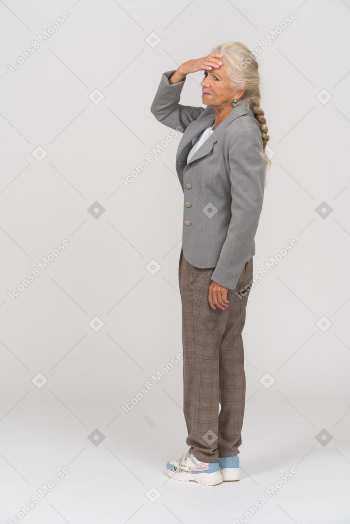 Retrovisor de uma senhora idosa de terno tocando a testa