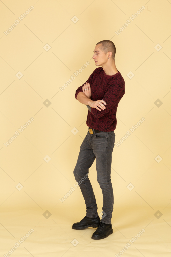 Three-quarter view of an offended young man crossing his hands