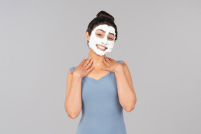 Woman with white facial mask on smiling